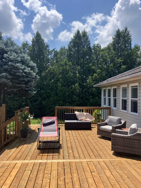 Finished backyard wood deck with railing and outdoor seating